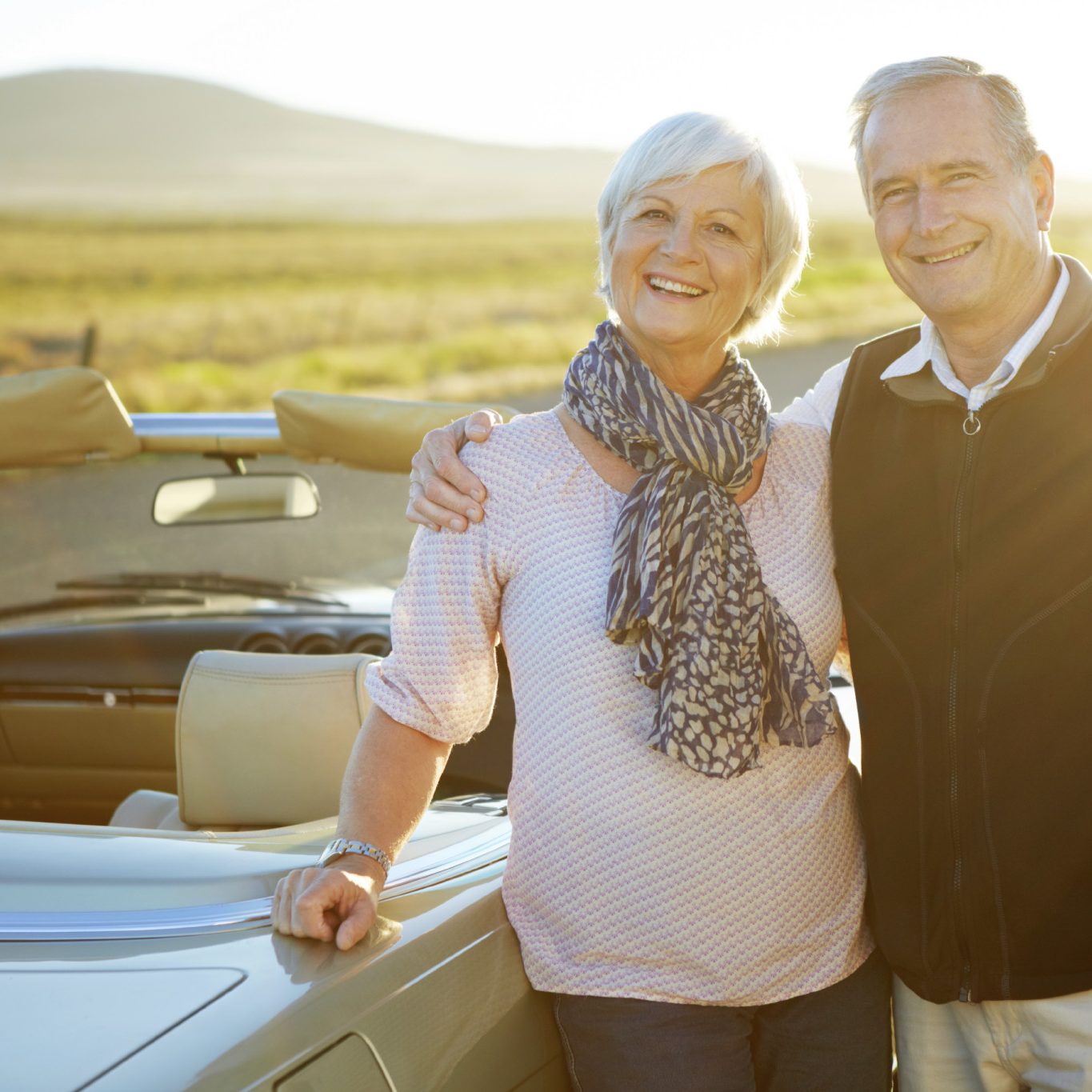 Portrait of an affectionate couple standing by their car by the side of the road